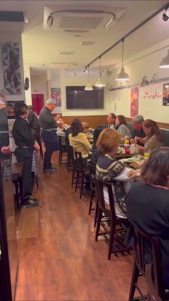 Guests dining and staff serving at Akariya during a busy evening