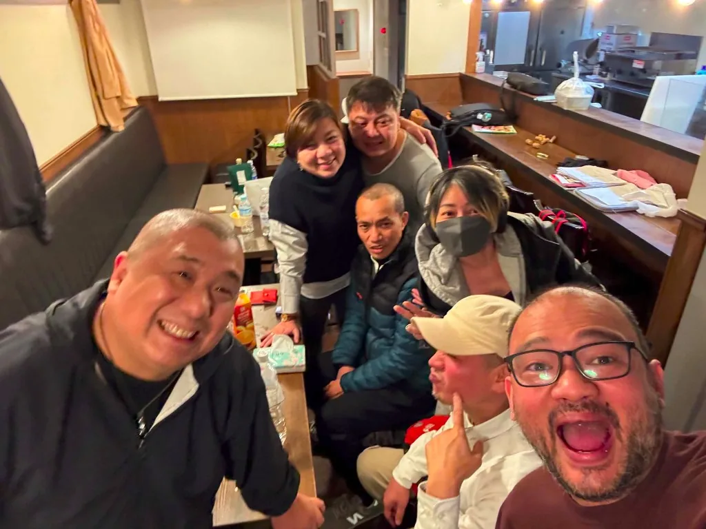 Akariya team and staff posing together inside the izakaya